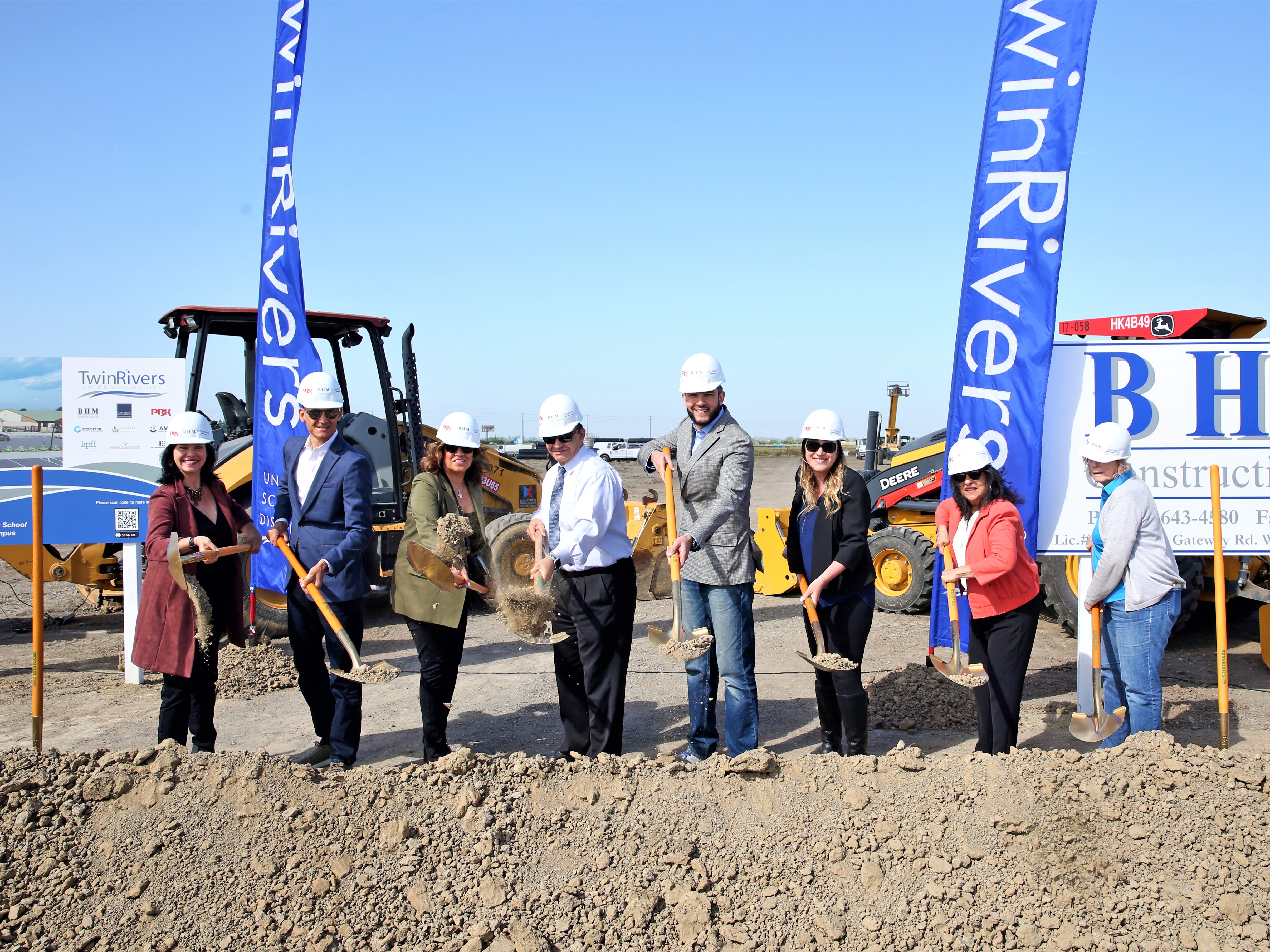 men and women breaking ground on new elementary school